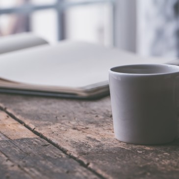 cup of coffee and journal on a distressed wooden table